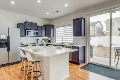 a kitchen with a white counter and a refrigerator at 6 Mi to DIA Denver Home with Fenced Yard and Fire Pit in Aurora