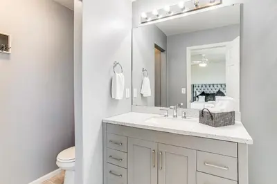 a white bathroom with a sink and a mirror at 6 Mi to DIA Denver Home with Fenced Yard and Fire Pit in Aurora