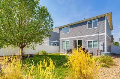 a house with a tree in the yard at 6 Mi to DIA Denver Home with Fenced Yard and Fire Pit in Aurora
