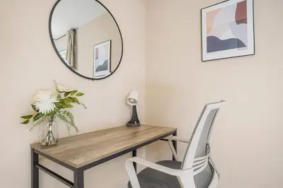 a mirror on a wall above a desk with a chair at Sweet Arvada Escape - Near Olde Town in Arvada