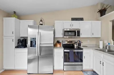 a kitchen with white cabinets and a stainless steel refrigerator at Wagon Trail in Littleton