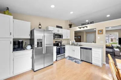 a kitchen with white cabinets and a stainless steel refrigerator at Wagon Trail in Littleton