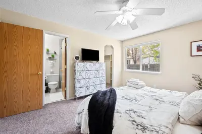 a bedroom with a bed and a television and a bathroom at Wagon Trail in Littleton