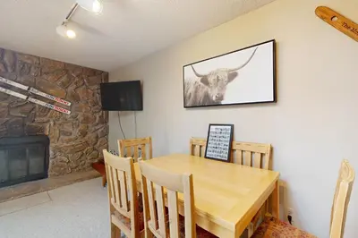 a dining room with a table and a cow on the wall at Frosty Peak Perch in Fraser