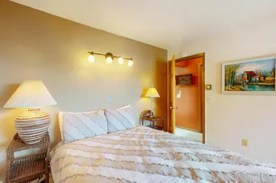 a bedroom with a bed and a lamp on a table at Frosty Peak Perch in Fraser