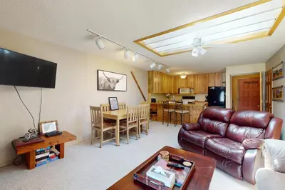 a living room with a leather couch and a table at Frosty Peak Perch in Fraser