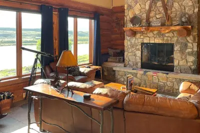 a living room with a couch and a stone fireplace at Bergamont Bliss in Tabernash