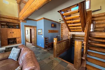 a living room with a couch and a staircase at Bergamont Bliss in Tabernash