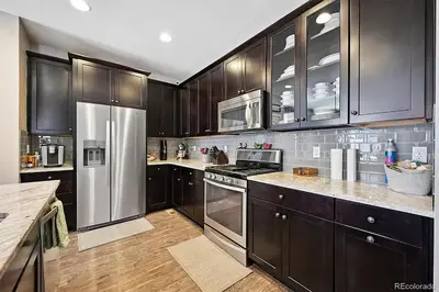 a kitchen with wooden cabinets and stainless steel appliances at 4BR Home close to Airport in Aurora