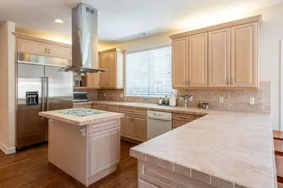 a kitchen with wooden cabinets and a stainless steel refrigerator at Luxurious 4BR Retreat - Pool Table & Chic Amenities in Boulder