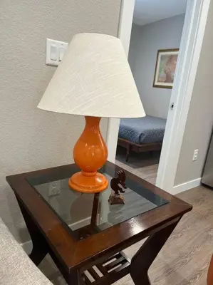 an orange lamp sitting on a glass table with a lamp at Stylish and cozy 2 bed in Brighton