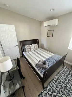 a bedroom with a bed and a table and a door at Stylish and cozy 2 bed in Brighton