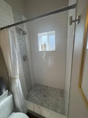 a bathroom with a shower with a toilet and a window at Elegant & cozy 2 bed in Brighton