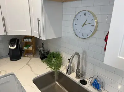 a kitchen with a sink and a clock on the wall at Elegant & cozy 2 bed in Brighton