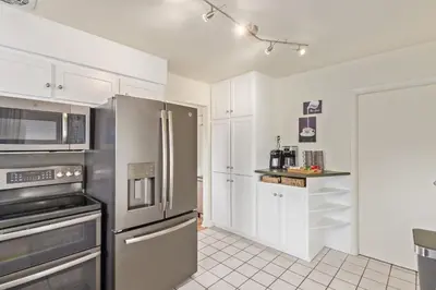 a kitchen with stainless steel appliances and white cabinets at NEW! 1958 Chic Mid-Mod House in Littleton