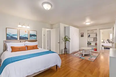 a bedroom with a large white bed with orange pillows at NEW! 1958 Chic Mid-Mod House in Littleton