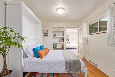 a bedroom with a white bed with blue pillows at NEW! 1958 Chic Mid-Mod House in Littleton