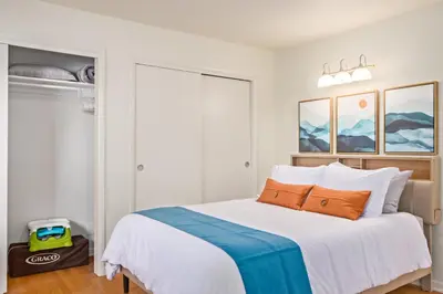 a bedroom with a large white bed with orange pillows at NEW! 1958 Chic Mid-Mod House in Littleton