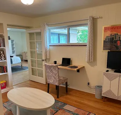 a room with a desk with a laptop and a table at NEW! 1958 Chic Mid-Mod House in Littleton