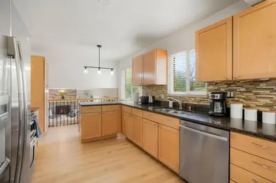 a kitchen with wooden cabinets and stainless steel appliances at Large Home, 2 Living Rooms, Great for Family/Pets! in Arvada
