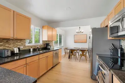 a kitchen with wooden cabinets and a dining room at Large Home, 2 Living Rooms, Great for Family/Pets! in Arvada