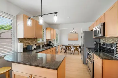 a kitchen with wooden cabinets and a counter top at Large Home, 2 Living Rooms, Great for Family/Pets! in Arvada