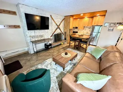 a living room with a couch and a table at Winter Haus, Winter Park 2 bedrooms corner unit w outdoor patio walking distance to the Center of town in Winter Park
