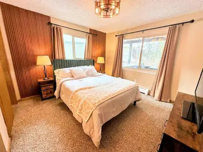 a bedroom with a large bed and a window at Winter Haus, Winter Park 2 bedrooms corner unit w outdoor patio walking distance to the Center of town in Winter Park