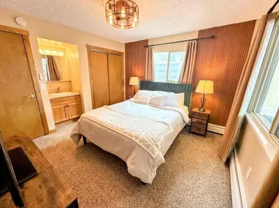 a bedroom with a large bed and a window at Winter Haus, Winter Park 2 bedrooms corner unit w outdoor patio walking distance to the Center of town in Winter Park