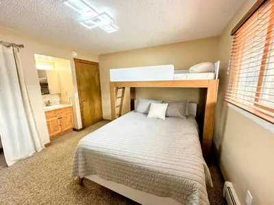 a bedroom with a bunk bed and a bathroom at Winter Haus, Winter Park 2 bedrooms corner unit w outdoor patio walking distance to the Center of town in Winter Park