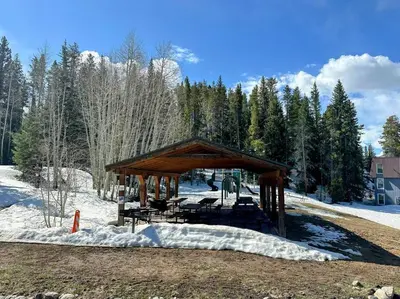 a gazebo with tables and chairs in the snow at Winter Haus, Winter Park 2 bedrooms corner unit w outdoor patio walking distance to the Center of town in Winter Park