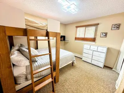 a bedroom with two bunk beds and a bed at Winter Haus, Winter Park 2 bedrooms corner unit w outdoor patio walking distance to the Center of town in Winter Park