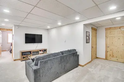 a living room with a couch and a flat screen tv at Tabernash Home about 13 Miles to Winter Park! in Tabernash