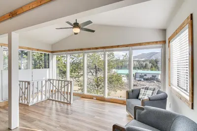 a living room with a ceiling fan and large windows at Tabernash Home about 13 Miles to Winter Park! in Tabernash