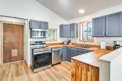 a kitchen with stainless steel appliances and wood floors at Tabernash Home about 13 Miles to Winter Park! in Tabernash