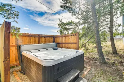 a hot tub sitting next to a wooden fence at Tabernash Home about 13 Miles to Winter Park! in Tabernash