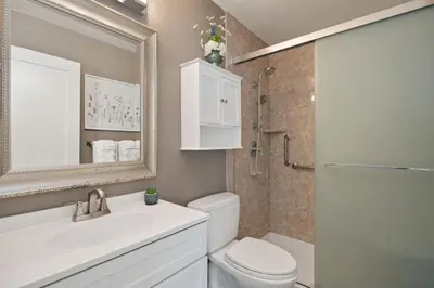 a bathroom with a toilet and a sink and a mirror at Spirit of the Rockies - Private Backyard & Hot Tub in Fort Collins