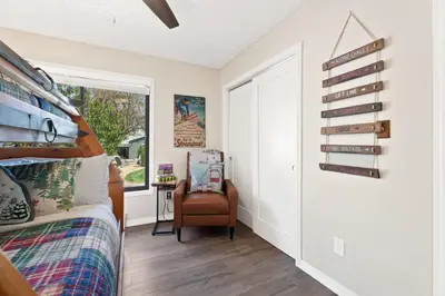 a bedroom with a bed and a chair and a window at Spirit of the Rockies - Private Backyard & Hot Tub in Fort Collins