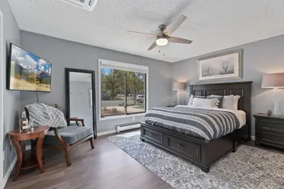 a bedroom with a bed and a chair and a window at Spirit of the Rockies - Private Backyard & Hot Tub in Fort Collins