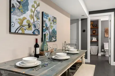 a dining room with a table with plates and wine glasses at Beautiful Old Town 2 Bedroom Apartment with Bikes! in Fort Collins