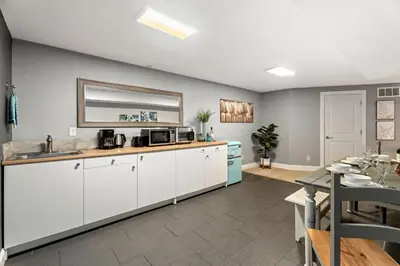 a kitchen with white cabinets and a dining room at Beautiful Old Town 2 Bedroom Apartment with Bikes! in Fort Collins