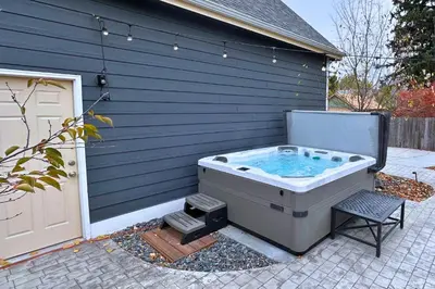 a hot tub sitting outside of a house with a chair at Beautiful Old Town 2 Bedroom Apartment with Bikes! in Fort Collins