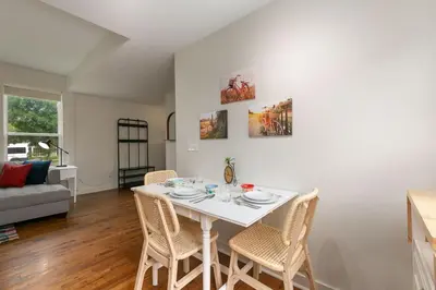 a dining room with a white table and chairs at Sherwood Cottage - Steps from Old Town & Poudre River in Fort Collins