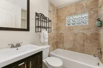 a bathroom with a sink and a tub and a toilet at Sherwood Cottage - Steps from Old Town & Poudre River in Fort Collins