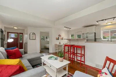 a living room with a couch and a table at Sherwood Cottage - Steps from Old Town & Poudre River in Fort Collins