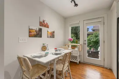 a white dining room with a white table and chairs at Sherwood Cottage - Steps from Old Town & Poudre River in Fort Collins