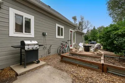 a backyard with a grill next to a house at Sherwood Cottage - Steps from Old Town & Poudre River in Fort Collins