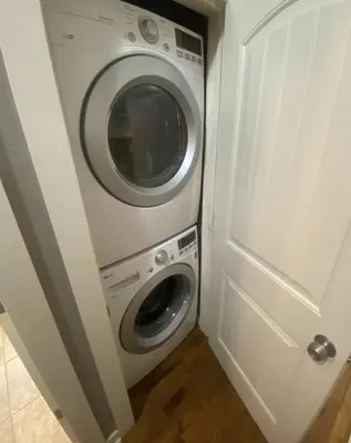 a washing machine sitting next to a white door at Sherwood Cottage - Steps from Old Town & Poudre River in Fort Collins