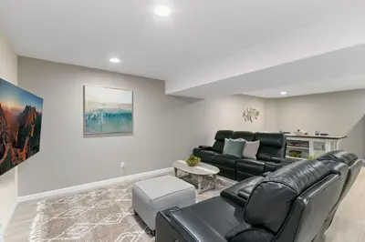 a living room with a black leather couch and a table at Colorado Mountain Retreat - Easy access to RMNP! in Loveland