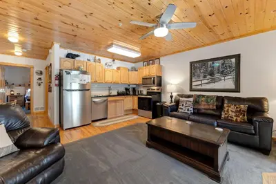 a living room with leather furniture and a kitchen at Bugle Pointe B04 by Estes Park Condos in Estes Park